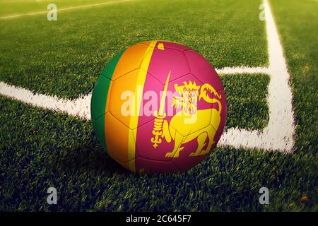 Drapeau Sri Lanka sur le ballon en position de coup de pied de coin, fond de terrain de football. Thème national du football sur gazon. Banque D'Images