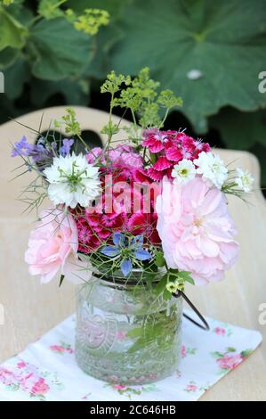 petit bouquet de roses roses et fleurs d'été dans vase en verre comme décoration Banque D'Images