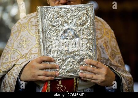 Bucarest, Roumanie - 24 mai 2020 : détails d'un prêtre orthodoxe lisant la Sainte Bible pendant un Baptême orthodoxe. Banque D'Images