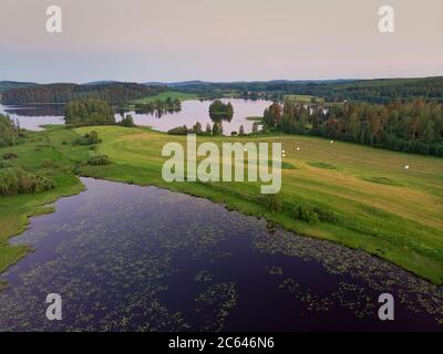 Un coucher de soleil d'été sur les lacs et les champs du centre de la Finlande. Les nuits sont très claires en été. Banque D'Images