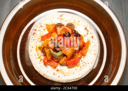 HARISSA REMUER LES LÉGUMES FRY SUR UN LIT DE HOUMOUS Banque D'Images