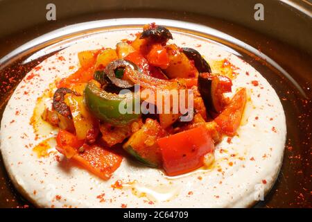 HARISSA REMUER LES LÉGUMES FRY SUR UN LIT DE HOUMOUS Banque D'Images