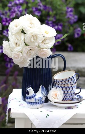 bouquet de roses blanches dans vase et tasses de café vintage comme décoration d'été Banque D'Images