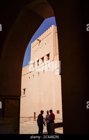 Nizwa / Oman - 15 février 2020 : groupe d'hommes sous l'arche avec vue panoramique sur le fort de Nizwa Banque D'Images