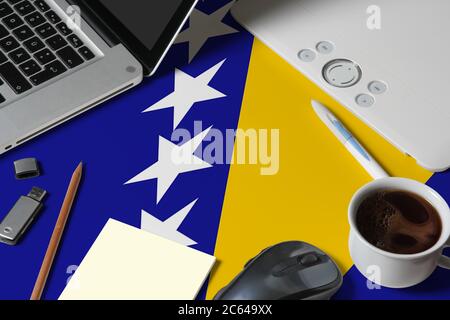 Drapeau national de Bosnie-Herzégovine sur la vue de dessus espace de travail de créateur avec ordinateur portable, clavier d'ordinateur, clé usb, tablette graphique, tasse de café, Mo Banque D'Images