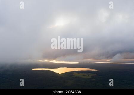 Vue aérienne nuages sur la forêt et le lac. Vue depuis drone. Vue aérienne sur le dessus du paysage nuageux. Texture des nuages. Vue de dessus. Lever du soleil ou coucher du soleil sur c Banque D'Images