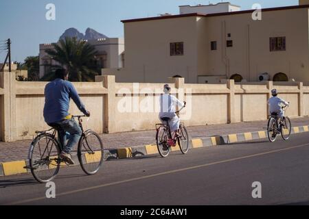 Bahla / Oman - 16 février 2020 : père et deux fils à vélo dans les rues de Bahla Banque D'Images