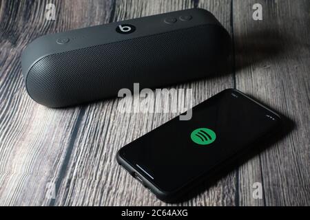 Un écran iphone 11 affichant l'icône spotify avec le haut-parleur Beats Pill à côté Banque D'Images