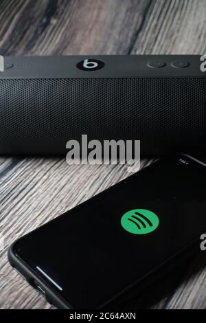 Un écran iphone 11 affichant l'icône spotify avec le haut-parleur Beats Pill à côté Banque D'Images