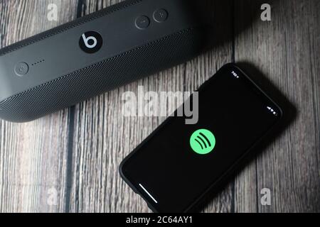 Un écran iphone 11 affichant l'icône spotify avec le haut-parleur Beats Pill à côté Banque D'Images