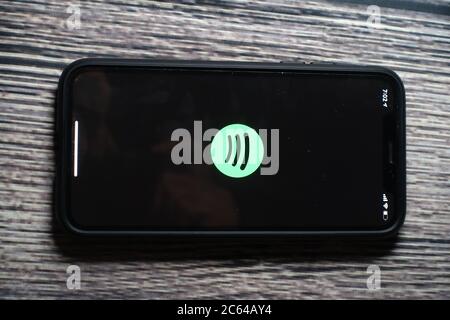 Un écran iphone 11 affichant l'icône spotify avec le haut-parleur Beats Pill à côté Banque D'Images