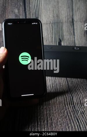 Un écran iphone 11 affichant l'icône spotify avec le haut-parleur Beats Pill à côté Banque D'Images