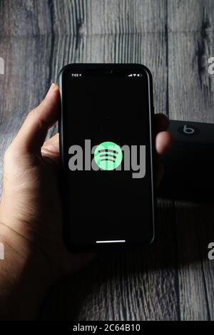 Un écran iphone 11 affichant l'icône spotify avec le haut-parleur Beats Pill à côté Banque D'Images
