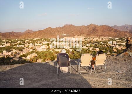 Bahla / Oman - 16 février 2020 : guide touristique et local bénéficiant d'une vue panoramique sur la ville de Bahla et le fort de Bahla au coucher du soleil Banque D'Images