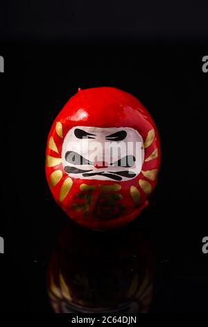 Daruma Doll isolé contre le noir Banque D'Images