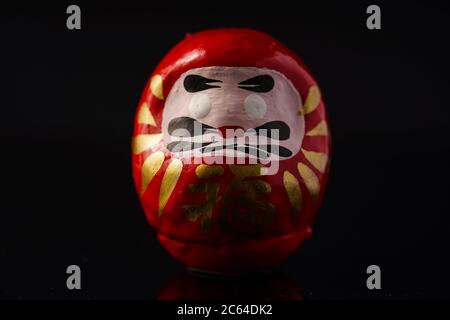 Daruma Doll isolé contre le noir Banque D'Images