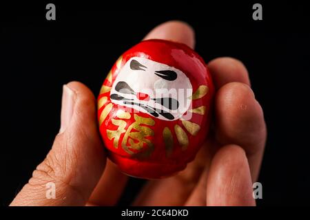 Daruma Doll isolé contre le noir Banque D'Images