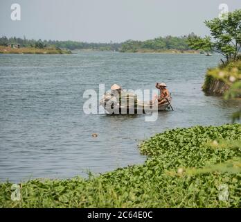 Deux habitants de la région ravirent sur la puissante rivière Thu bon dans le Vietnam rural. Banque D'Images
