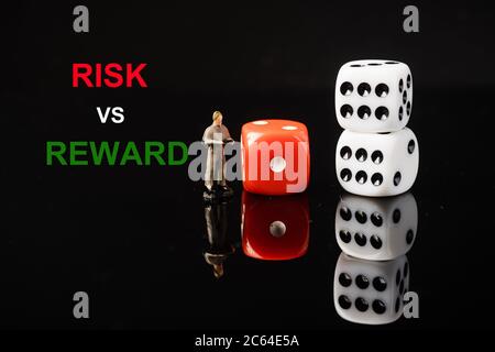 Libellés « RISQUE vs RÉCOMPENSE » avec des dés rouges et blancs, cliché conceptuel. Banque D'Images