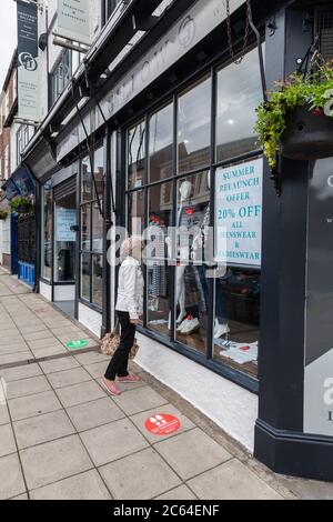 Une femme regarde la fenêtre de la boutique Geoffrey Gilliw à Darlington, Co.Durham, Angleterre, Royaume-Uni Banque D'Images