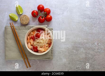 Nouilles diététiques cétogènes shirataki konjak avec crevettes et tomates dans un bol avec baguettes. Banque D'Images