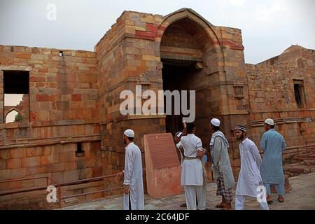 Touristes religieux ayant une discussion à l'une des portes du complexe Qutb Minar à Mehrauli, New Delhi, Inde. Banque D'Images