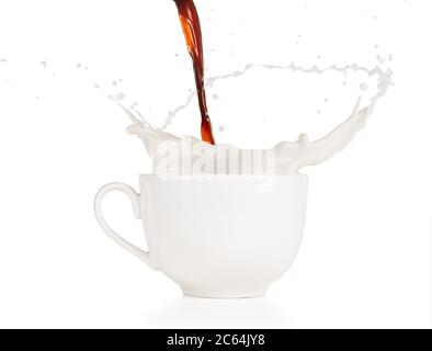 café qui coule dans une tasse de lait éclabousse isolée sur fond blanc Banque D'Images