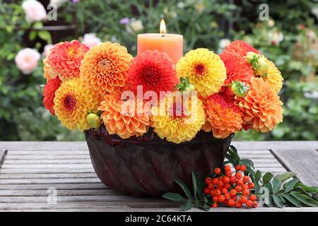 décoration d'automne avec bougie et dahlias orange et jaune dans le vieux moule guglhupf Banque D'Images