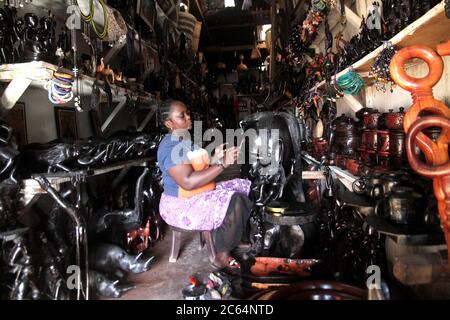 Dar es Salaam. 7 juillet 2020. Une propriétaire de magasin polit les sculptures sur bois dans son magasin vide du marché des sculpteurs sur bois de Mwenge à Dar es Salaam, Tanzanie, le 6 juillet 2020. En raison de l'épidémie de COVID-19, les marchés d'œuvres d'art de la ville autrefois populaires parmi les touristes étrangers sont presque vides maintenant. Crédit: Xinhua/Alay Live News Banque D'Images