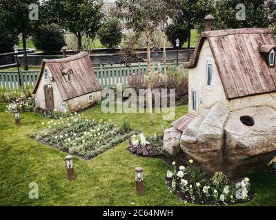 Russie, Sotchi 14.03.2020. Deux petites maisons de conte de fées sur la pelouse avec des lits de fleurs lanternes basse clôture derrière et des arbres dans le fond Banque D'Images