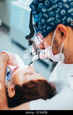 Minsk, Bélarus - 11 juin 2020 : le dentiste sèche et durcit le matériau de remplissage à l'aide de radiations Banque D'Images