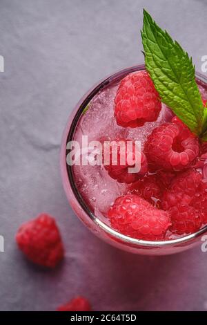 Glace fraîche jus de baies froide avec menthe, limonade d'été à la framboise en verre sur fond de béton de pierre, vue du dessus macro Banque D'Images