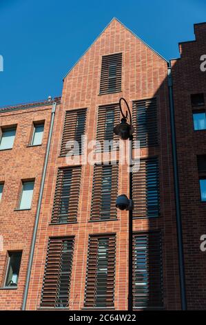 Architecture moderne dans le vieux port de Gdansk, Pologne. Bâtiment en brique rouge avec fenêtres à volets. Banque D'Images