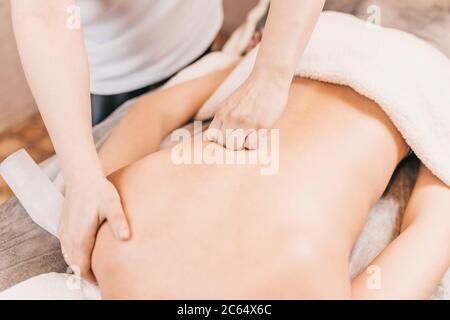 Mains d'un professionnel masseur au travail - un effet dur profond sur les muscles et les tissus d'une personne Banque D'Images