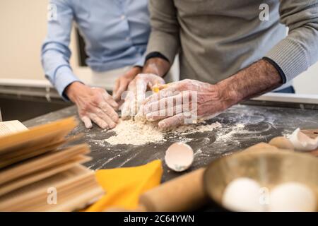 Couple debout dans une cuisine, faisant des pâtes maison fraîches. Banque D'Images