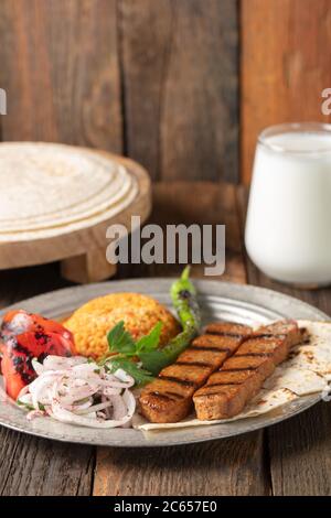 Adana Kebap turc avec riz pilaf et légumes servis sur une assiette Banque D'Images