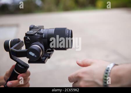 Opérateur de nacelle avec équipament noir - stabilisateur et caméra de cinéma . Un homme non identifié tenant la nacelle un stabilisateur de caméra . Homme tenant la nacelle Banque D'Images