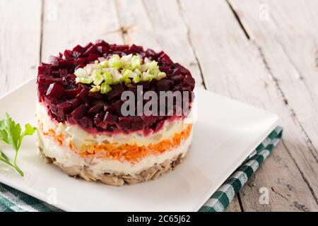 Salade de hareng russe traditionnelle avec betterave et carottes sur table en bois Banque D'Images