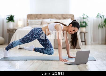 Entraînement à domicile. Jeune fille asiatique pratiquant le sport devant un ordinateur portable Banque D'Images