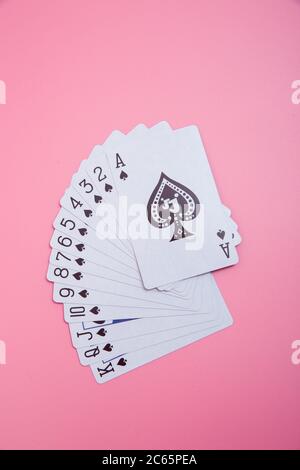 Cartes à jouer étendues sur fond rose Banque D'Images