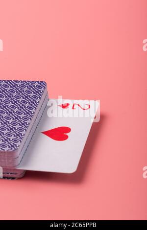 Cartes à jouer étendues sur fond rose Banque D'Images