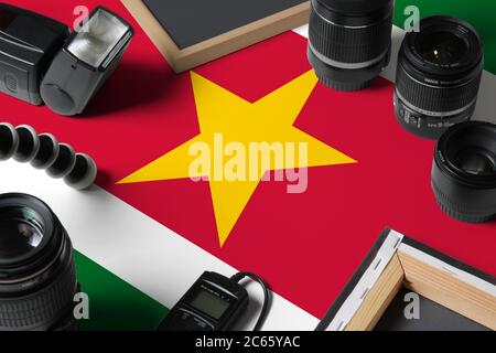 Drapeau national du Suriname avec vue de dessus de l'équipement et des outils de photographe personnel sur table en bois blanc, espace de copie. Banque D'Images