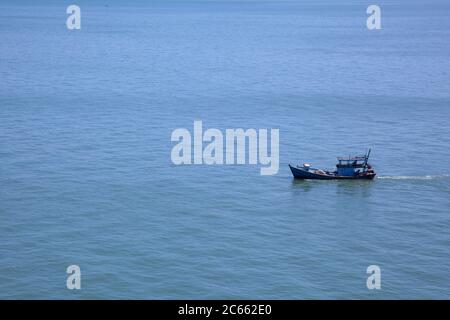 Bateau de pêche bleu solitaire sur une vaste mer calme sans autre sujet sur la scène de la mer de Chine méridionale près du Vietnam. Banque D'Images