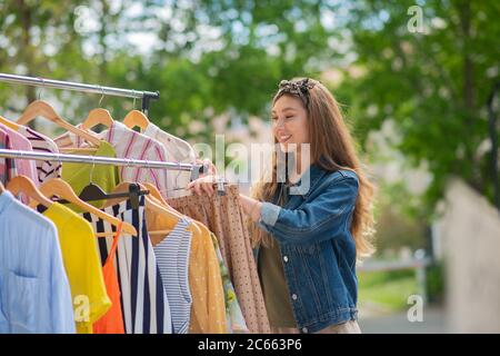 Jolie femme attrayante choisissant des vêtements élégants pour elle-même Banque D'Images