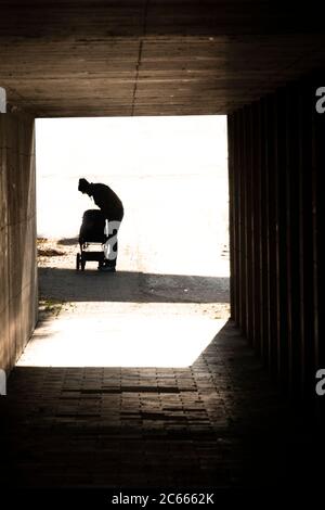 Homme avec pram devant un passage sombre, Munich, Bavière, Allemagne Banque D'Images