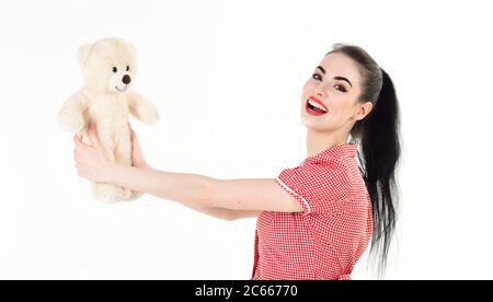 Jolie jeune femme souriante en tricoté tenant un ours en peluche sur un fond blanc isolé Banque D'Images