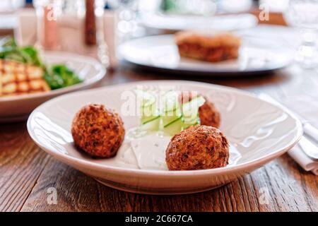 Croquettes de courgettes et autres plats sur la table du restaurant, cuisine grecque, tons Banque D'Images