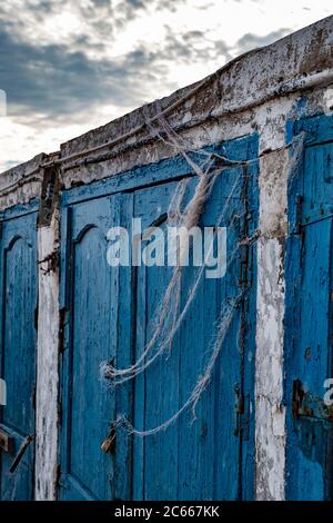 Anciennes portes en bois bleu pour le stockage des ustensiles de pêche Banque D'Images