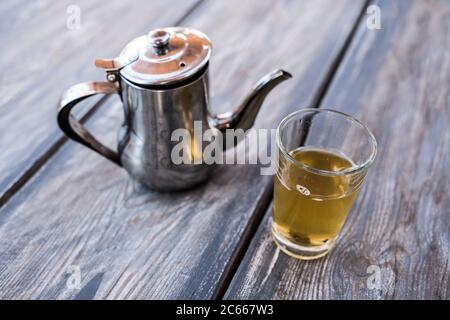 Boire du thé, de la théière et du thé à la menthe poivrée dans un verre à thé Banque D'Images