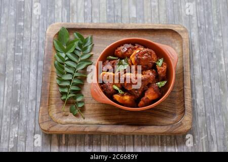 Poulet frit ou poulet frit kabab qui est bien garni de feuilles de curry dans une poêle noire avec fond gris ou des articles du terrorde Banque D'Images